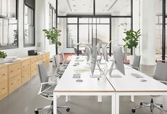 an empty office with desks and chairs in front of large windows that look out onto the city