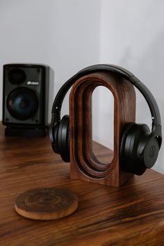 headphones on top of a wooden table next to an audio device and speaker system