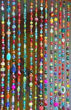 colorful beaded necklaces are hanging from the ceiling