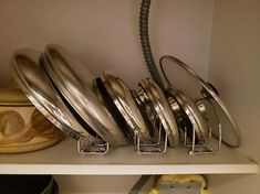 there are many pots and pans on the shelf