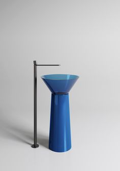 a blue vase sitting on top of a table next to a black stick and pole