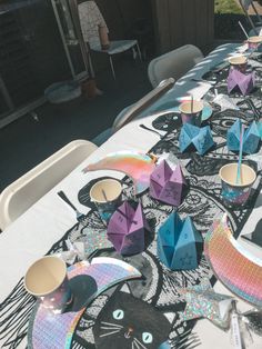 an outdoor table set up with paper cats