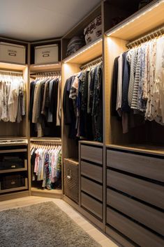 an organized closet with clothes hanging on the shelves, drawers and other items in it