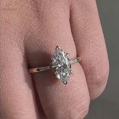 a woman's hand with a diamond ring on top of her finger and an engagement band