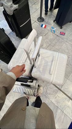 a person sitting on the ground next to some suitcases and other luggage in front of them