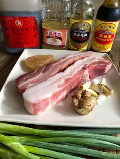 some meat and vegetables on a white plate with seasoning next to the ingredients for this dish