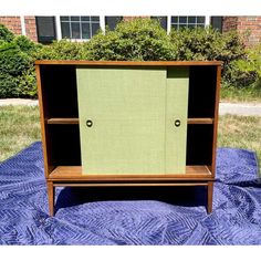 a green cabinet sitting on top of a blue blanket