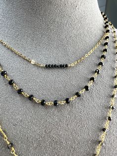 This is simple, beautiful necklace is comprised of 3mm Faceted Black Spinel hand-wrapped into a rosary style chain. Finished off with dangle of gold beads. Necklace length 16" with a 2" extender. Rosary chain is vermeil. All other components are gold filled. Black Beaded Chain Lariat Jewelry, Black Beaded Lariat Necklace Gift, Gold Multi-strand Necklace With Black Beads, Black Lariat Chain Necklace, Adjustable Double Strand Beaded Chain Necklace, Layering Beaded Necklaces With Adjustable Chain, Black Chain Necklaces For Layering, Gold Crystal Necklace With Black Beads As Gift, Gold Crystal Necklace With Black Beads For Gift