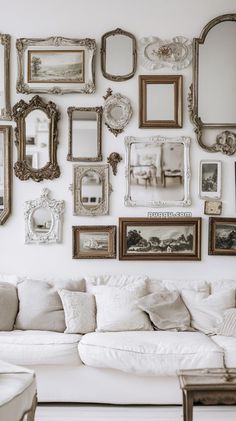 a living room filled with lots of frames on the wall