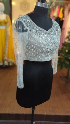 Beautiful silver sequin and mirrors hand embroidered blouse. Custom fitted.  base fabric : net all over embroidery in sequins, rhinestones, mirrors and zari thread The blouse will be made to order in your size or you can choose a standard size from the drop down. I'll send you a measurement sheet once you order for the measurements. Please convo me if you have any questions or need any customisation. Designer Hand Embellished Party Tops, Festive Hand Embellished Tops For Designer Wear, Festive Hand Embellished Designer Tops, Bollywood Designer Hand Embellished Blouse, Glamorous Sequins Tops, Traditional Hand Embellished Blouse For Reception, Traditional Hand Embellished Tops For Designer Wear, Bollywood Style Hand Embellished Festive Tops, Festive Bollywood Hand Embellished Tops