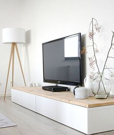 a flat screen tv sitting on top of a white entertainment center in a living room