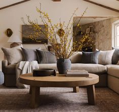 a living room filled with furniture and a large mirror on the wall above the couch