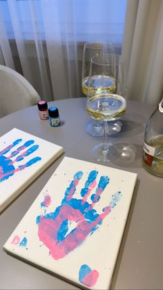 two handprints are on the table next to some wine glasses and a bottle