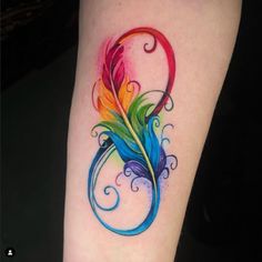 a colorful feather tattoo on the left arm and leg, with swirls around it