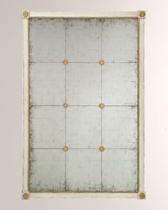 a white and gold framed mirror with four golden knobs on the bottom half of it