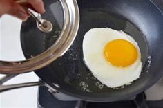 an egg is frying in a pan on the stove