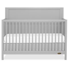 a gray crib with white sheets on it