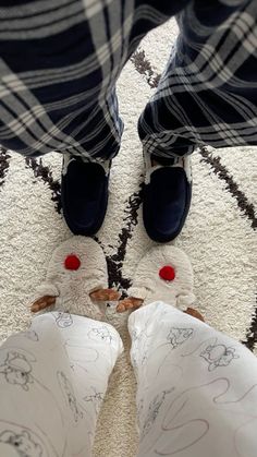 two people standing in front of a rug with their feet on the ground wearing slippers