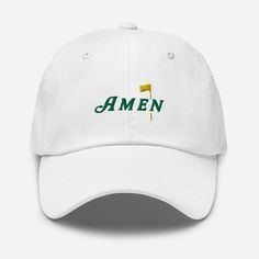 Capture the essence of Augusta with our exclusive Masters-inspired hat. Crafted with meticulous detail, it showcases intricate embroidery of the revered AMEN phrase, echoing the spirit of tradition and excellence synonymous with the prestigious tournament. Whether you're on the course or cheering from the sidelines, this hat is a must-have for every golf aficionado's collection. * 100% chino cotton twill * Green Camo color is 35% chino cotton twill, 65% polyester * Unstructured, 6-panel, low-profile * 6 embroidered eyelets * 3 ⅛" (7.6 cm) crown * Adjustable strap with antique buckle * Blank product sourced from Vietnam or Bangladesh This product is made especially for you as soon as you place an order, which is why it takes us a bit longer to deliver it to you. Making products on demand in Golf Hats, Camo Colors, The Masters, Intricate Embroidery, Green Camo, Trucker Cap, Low Profile, Cotton Twill, Baseball Cap