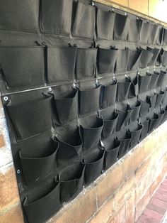 a wall that has some bags hanging on it's side and is made out of black fabric