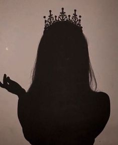 the silhouette of a woman with a crown on her head and hands in front of her face