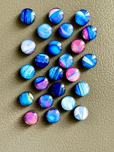 several different colored marbles are arranged on the floor in a pattern that looks like they have been painted with acrylic paint