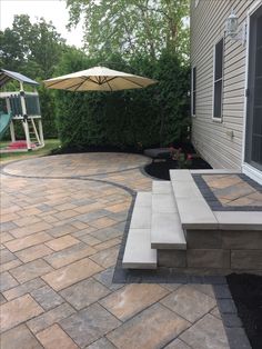 a patio with steps and an umbrella in the background