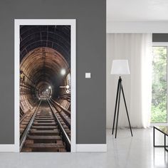 an open door with a train track going through it in the middle of a room