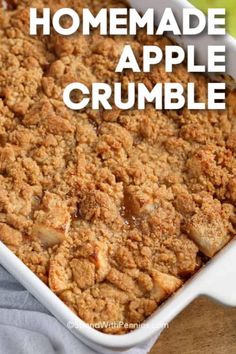 homemade apple crumble in a white baking dish on a wooden table with text overlay