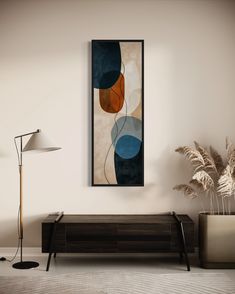 an abstract painting hangs on the wall next to a modern dresser and lamp in a living room