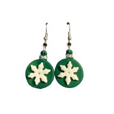 green and white earrings with snowflakes hanging from the ear wires on a white background