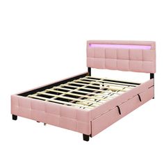 a pink bed frame with two drawers underneath it