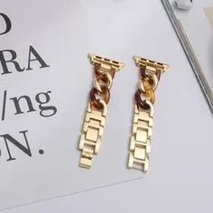 two pairs of gold toned chain link earrings on top of a white piece of paper