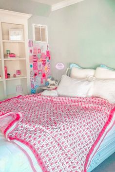 a bed with red and white bedspread in a bedroom next to a book shelf