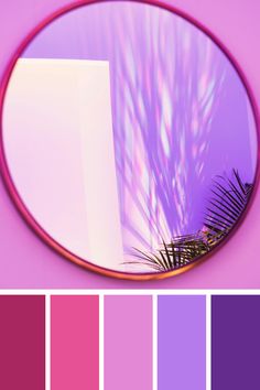 a mirror that has some pinks and purples in front of it with palm leaves