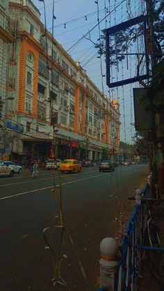 an empty city street with cars parked on the side