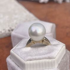 Two-tone 14KT white gold + yellow gold band ring with genuine, cultured Paspaley South Sea Pearl. Choose your finger size Contact us for additional sizes 12mm Paspaley Pearl; "Fine" quality; "Circle" shape Paspaley Certificate of Authenticity included Weight: 6.31g Made to order: please allow 7-10 business days prior to shipping Pearl will vary slightly from photos Timeless White Pearl Ring, Classic White Dome Ring For Wedding, White Pearl Ring With Round Band, Fine Jewelry White Pearl Ring With Round Band, White Pearl Ring Fine Jewelry, White Polished Pearl Ring, White Round Pearl Ring With Polished Finish, White Pearl Ring With Polished Finish, White Dome Ring Fine Jewelry