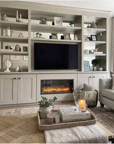 a living room filled with furniture and a flat screen tv mounted on the wall above a fire place