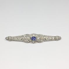 Victorian Platinum Diamond and Sapphire Bar Pin-Estate-Howard's Diamond Center Formal Sapphire Diamond Brooches, Formal Sapphire Diamond Brooch, Classic Platinum Brooches With Diamond Accents, Classic Diamond Brooch With Gemstones, Classic Platinum Brooches, Classic Diamond Gemstone Brooches, Elegant Silver Sapphire Brooches, Classic Platinum Brooch For Anniversary, Classic Platinum Brooches For Anniversary