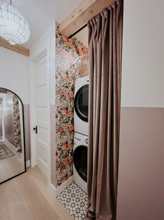 a washer and dryer in a room with floral wallpaper on the walls