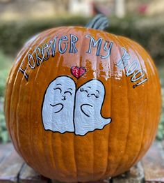 a pumpkin decorated with two ghost faces and the words'forever my bride'painted on it