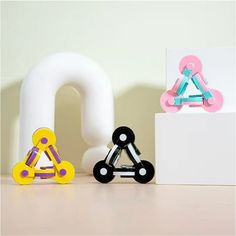 two wooden toys are sitting next to each other in front of the letter q,