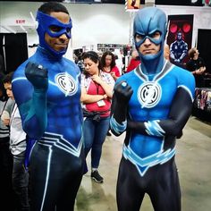 two men in blue and black costumes are standing next to each other at an event