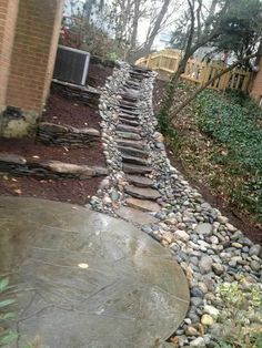 there is a stone path going up the side of this house in front of a brick building