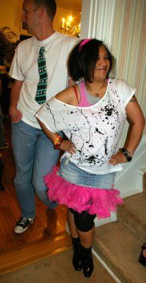 a man standing next to a woman in a pink skirt and white shirt on the stairs