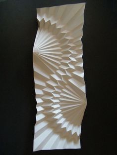 an intricate paper sculpture is displayed on the wall