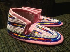 a pair of pink slippers with beads on them