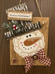 a wooden plaque with a snowman decoration on it's face and the words hakes welcome