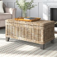 a living room with a wicker coffee table in front of a fire place and couch