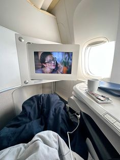 the inside of an airplane with a woman on it's screen and other items